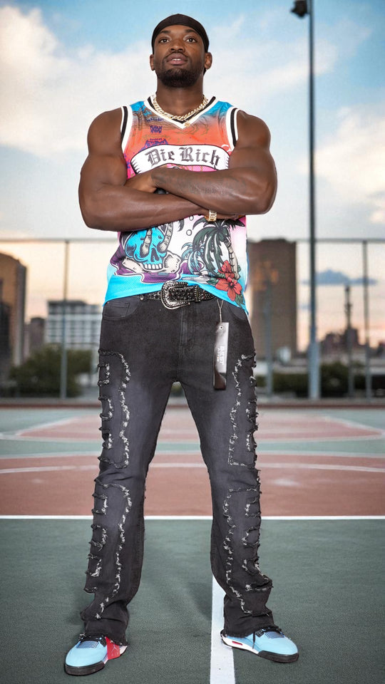 Person wearing a colorful tank top and ripped jeans standing on a basketball court.