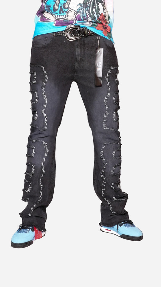 Person wearing black distressed jeans with a city skyline in the background