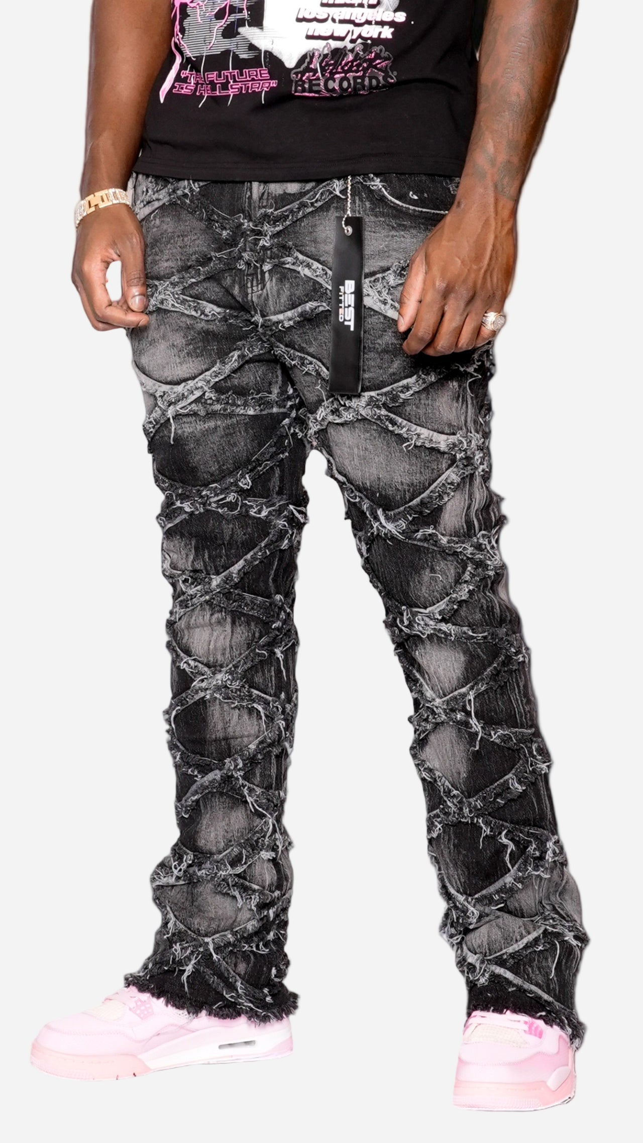 Person wearing black distressed jeans with a white background