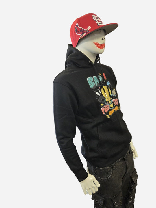 Mannequin wearing a black hoodie with colorful graphics and a red cap on a white background