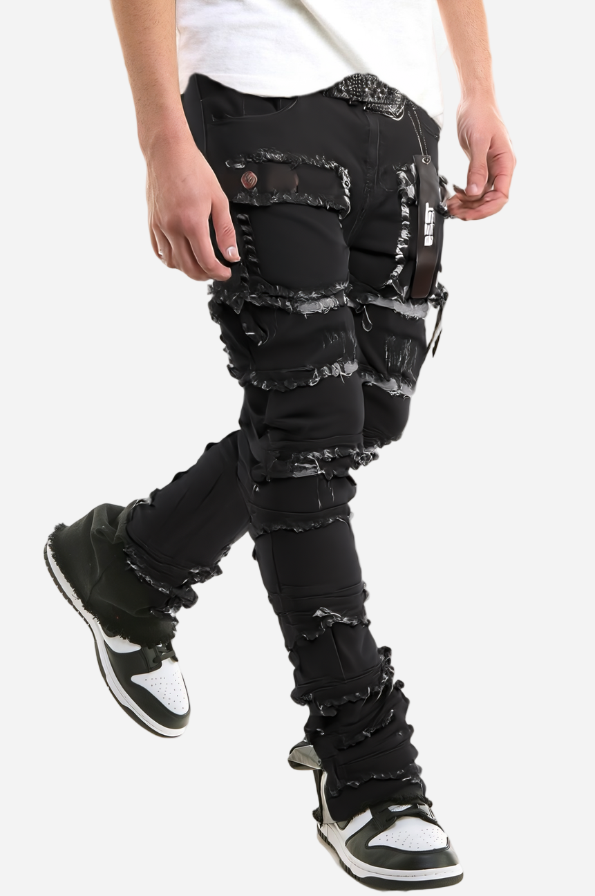 Person wearing black distressed jeans with a white background